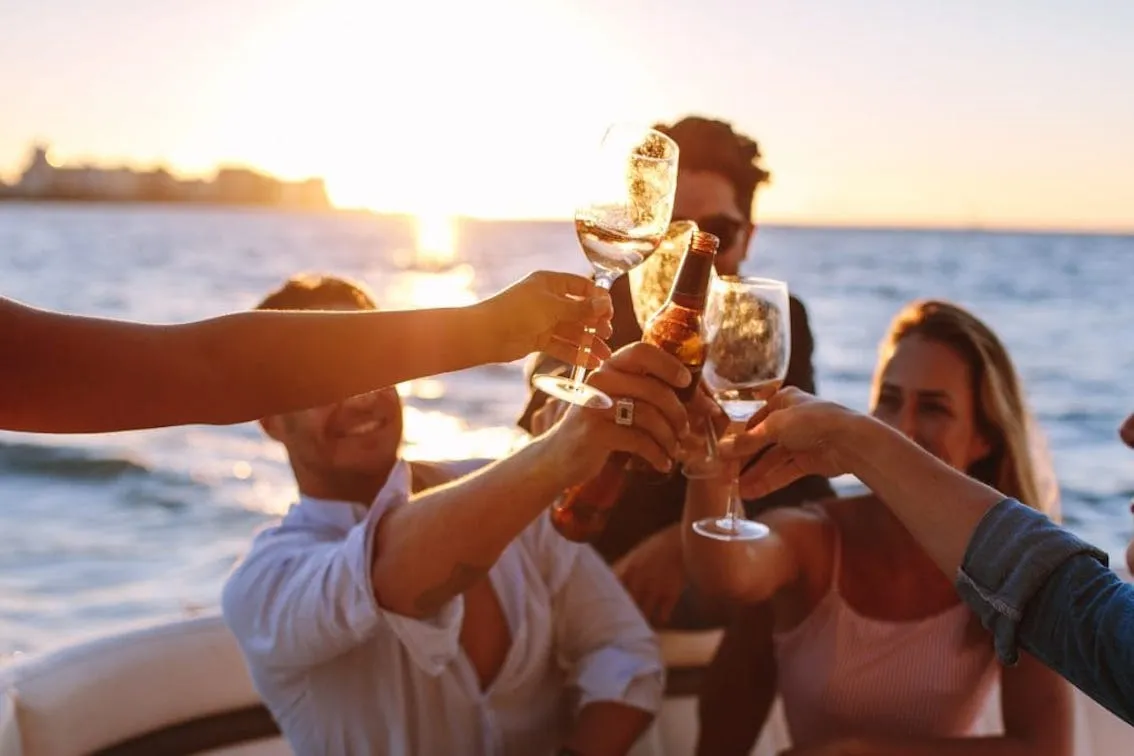 Amici al tramonto con aperitivo in barca
